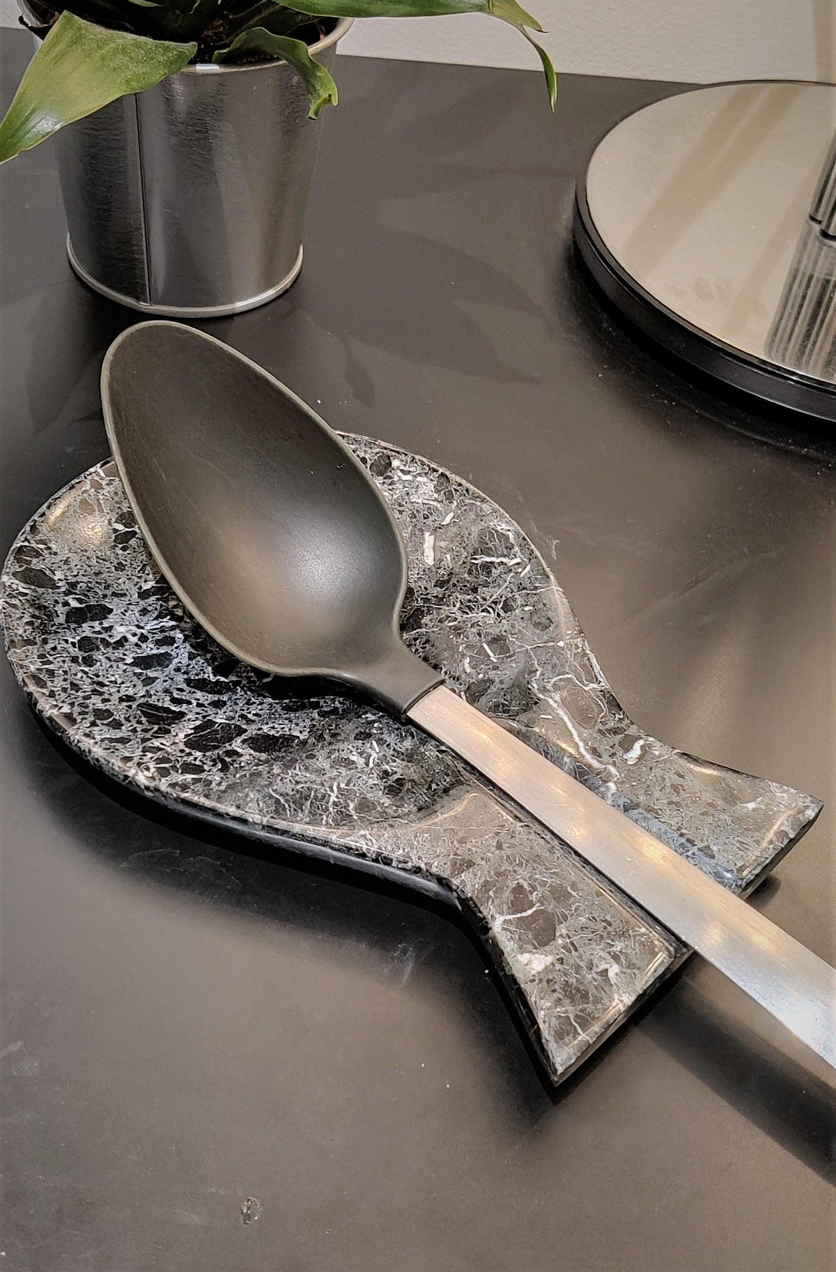 Black marble spoon rest holding a serving spoon