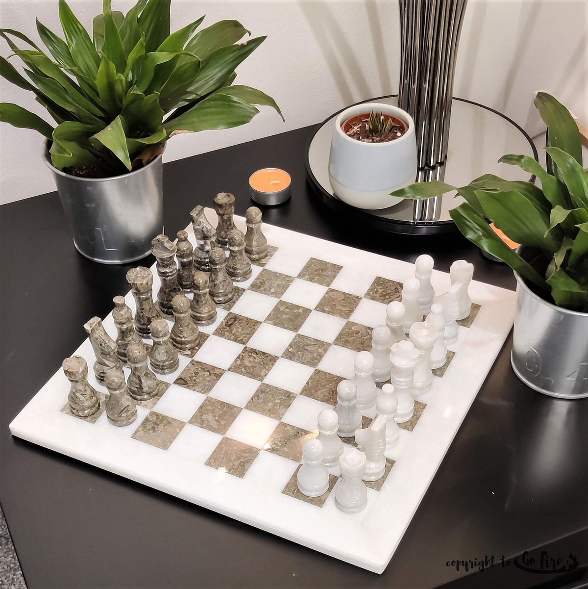 Grey and white marble chess pieces on a white board, angled