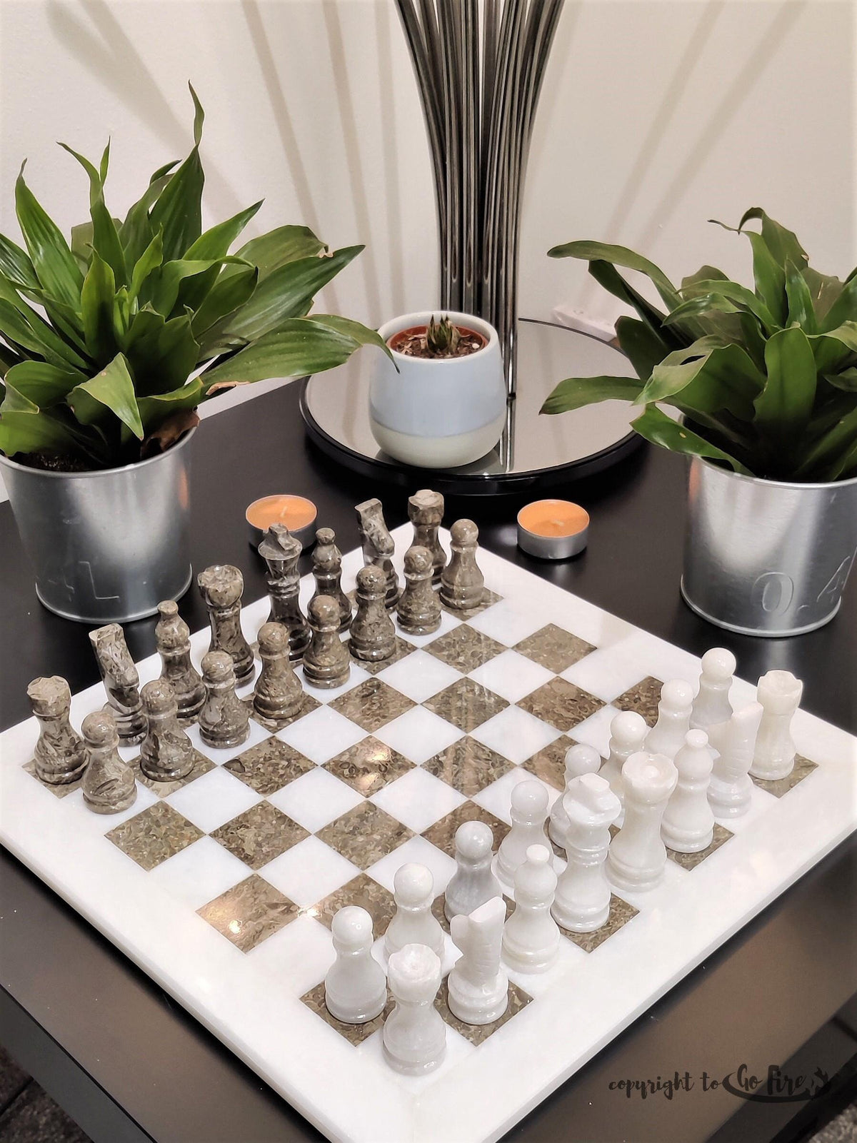 White and natural grey stone chess set on a dark side table