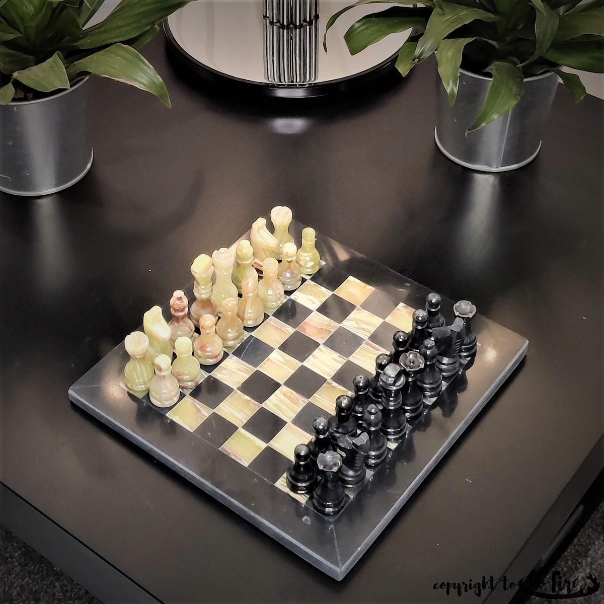 Black and onyx marble chess set on a dark side table