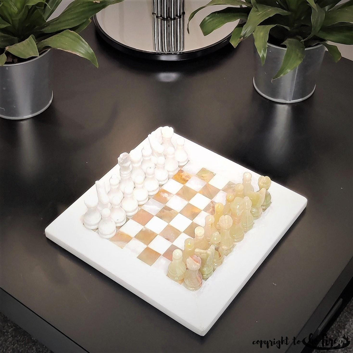 Green onyx and white chess set on a dark table