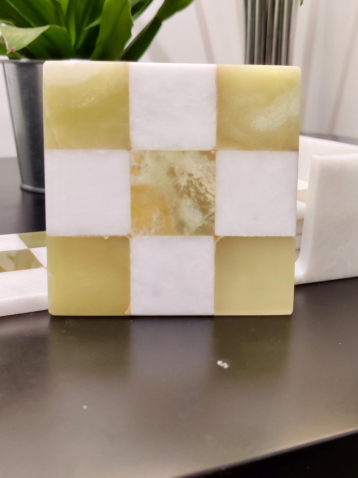Close-up of a green onyx and white checked marble coaster