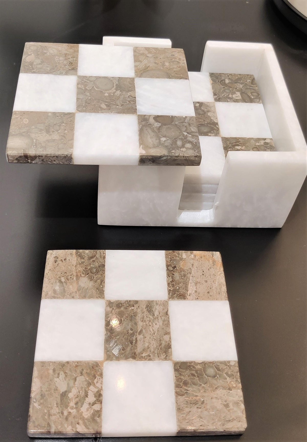 Close-up of grey and white marble coasters and holder