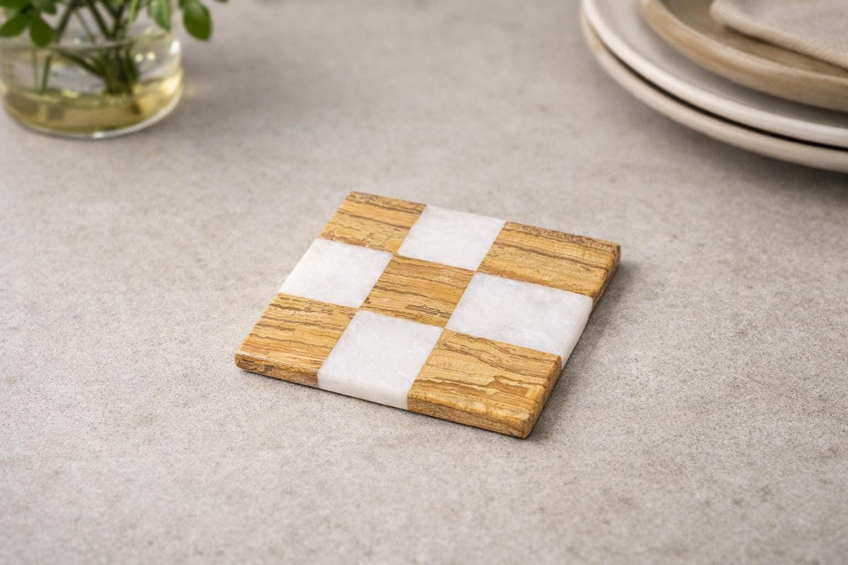 Brown and white checked marble coaster on a grey surface